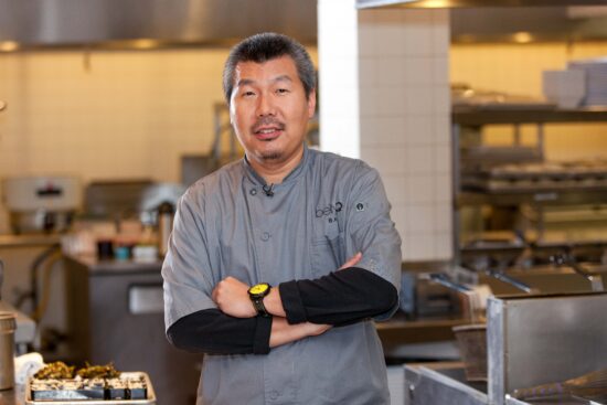 A Chef in a Grey Apron Holding Hands